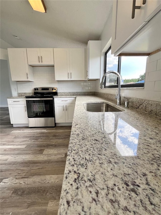 kitchen featuring light stone counters, sink, white cabinetry, and stainless steel electric range oven