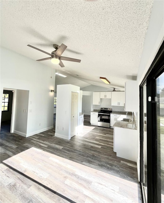 kitchen featuring sink, stainless steel range with electric cooktop, white cabinetry, vaulted ceiling, and hardwood / wood-style floors