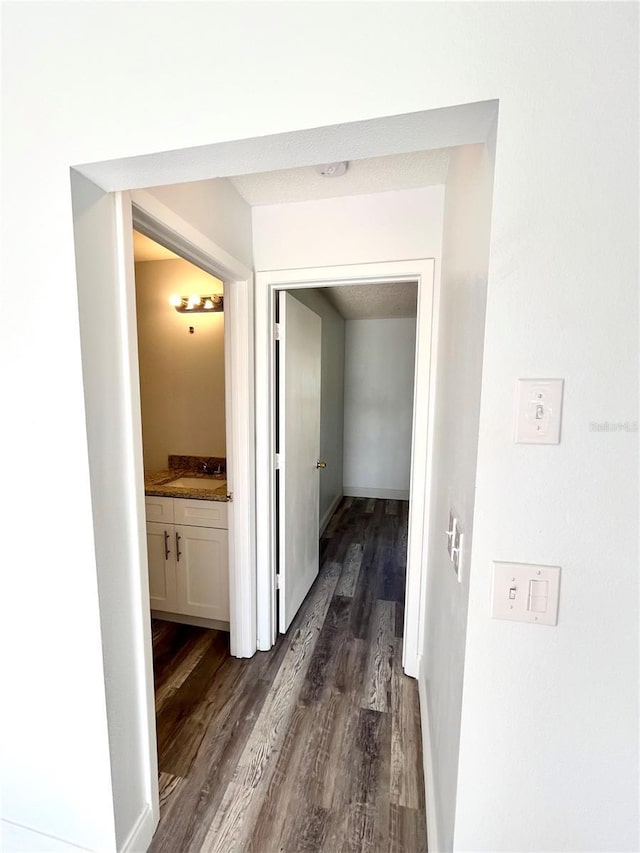 corridor featuring sink and dark hardwood / wood-style floors