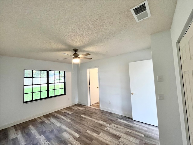 unfurnished bedroom featuring hardwood / wood-style flooring, ceiling fan, and a textured ceiling