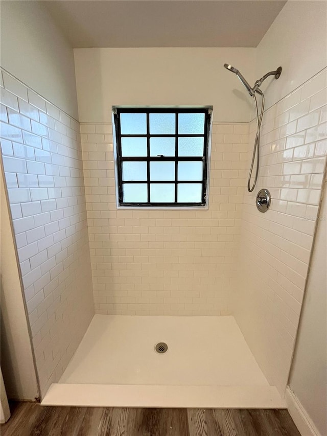 bathroom featuring a tile shower and hardwood / wood-style floors