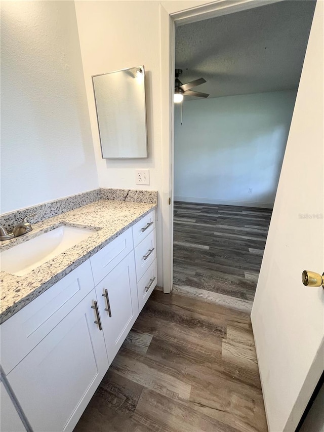 bathroom with hardwood / wood-style flooring, vanity, a textured ceiling, and ceiling fan