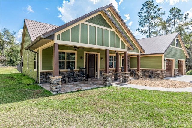 craftsman-style home featuring a garage, a front lawn, ceiling fan, and covered porch