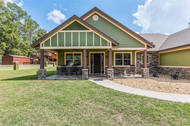 craftsman-style home featuring covered porch, a front yard, and ceiling fan