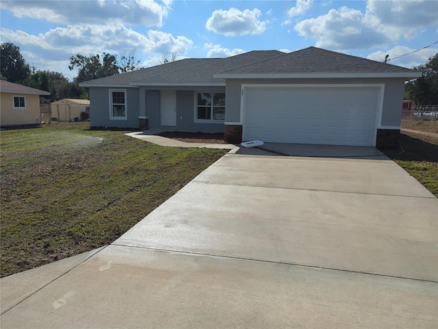 view of front of property with a garage, driveway, a front lawn, and stucco siding