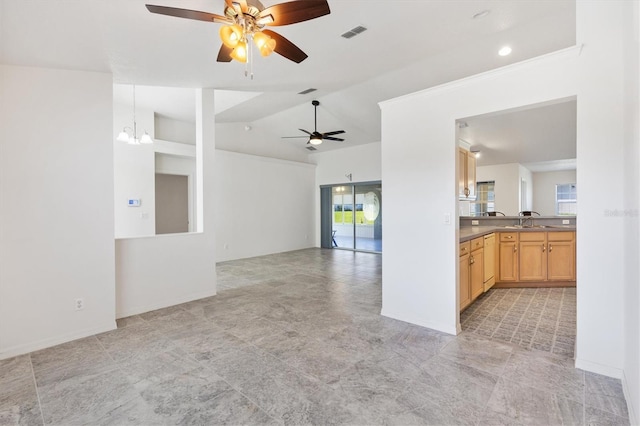 spare room featuring lofted ceiling, ceiling fan with notable chandelier, a sink, visible vents, and baseboards