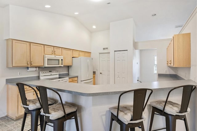 kitchen featuring a peninsula, white appliances, high vaulted ceiling, and a kitchen breakfast bar