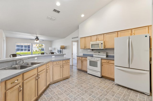 kitchen with white appliances, a sink, light floors, and light brown cabinetry