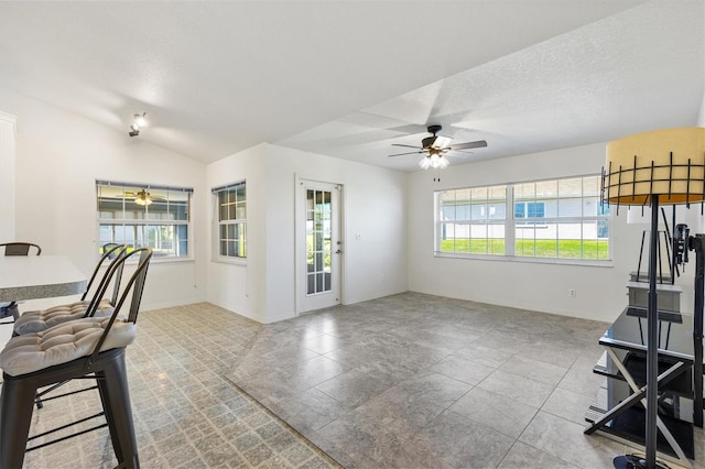 interior space with a healthy amount of sunlight, ceiling fan, a textured ceiling, and lofted ceiling