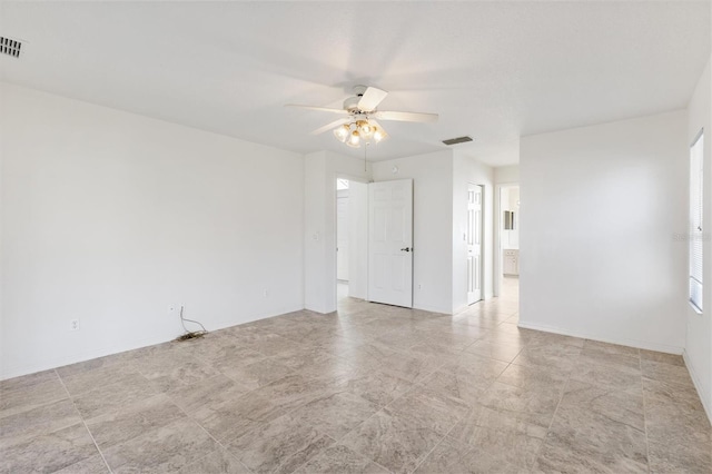 unfurnished room with baseboards, visible vents, and a ceiling fan