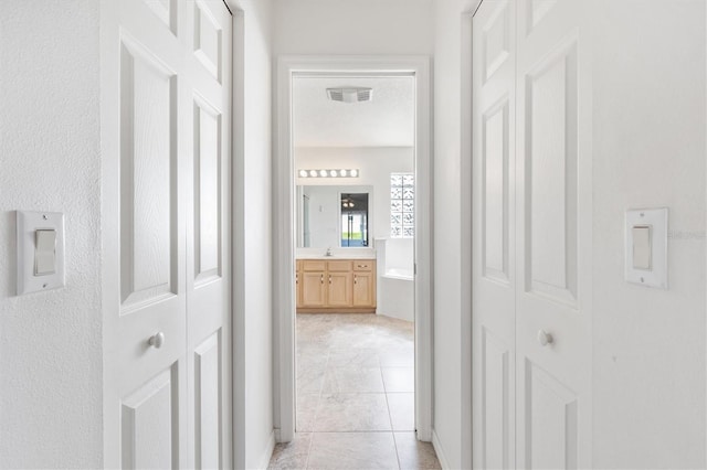 hallway featuring a sink and visible vents