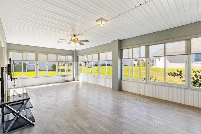 unfurnished sunroom featuring a ceiling fan