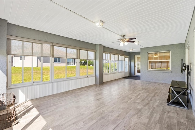 unfurnished sunroom with ceiling fan