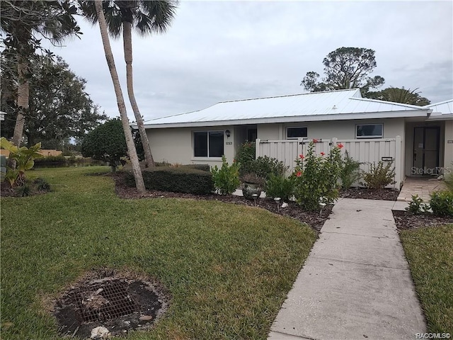 single story home with metal roof and a front lawn