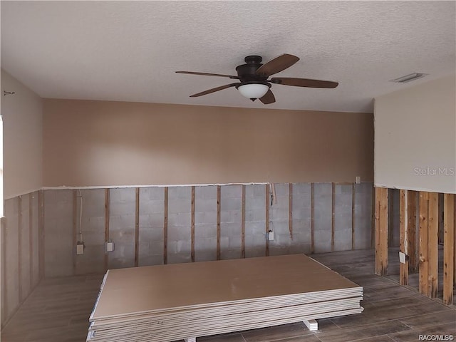 unfurnished room featuring a ceiling fan, visible vents, a textured ceiling, and wood finished floors