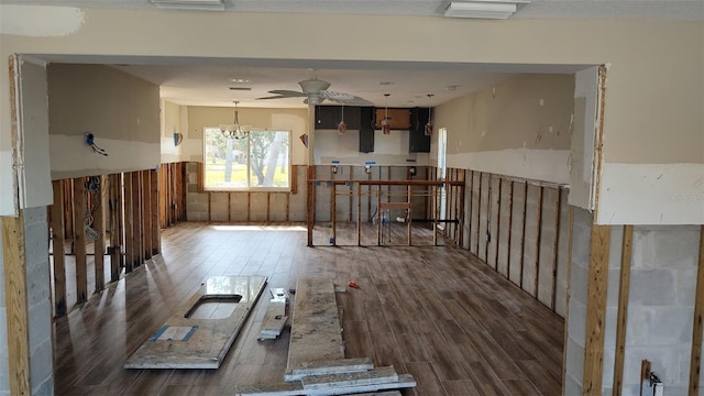 unfurnished room with visible vents, wood finished floors, and ceiling fan with notable chandelier