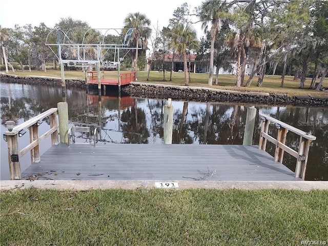 dock area with a water view and a yard