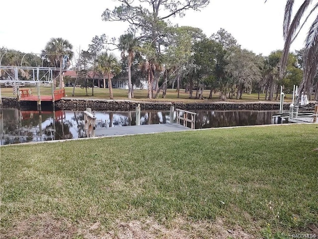 dock area with a water view and a lawn