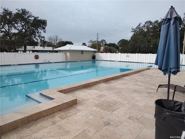 community pool with fence and a patio