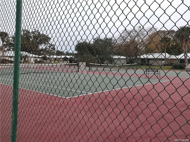 view of tennis court featuring fence