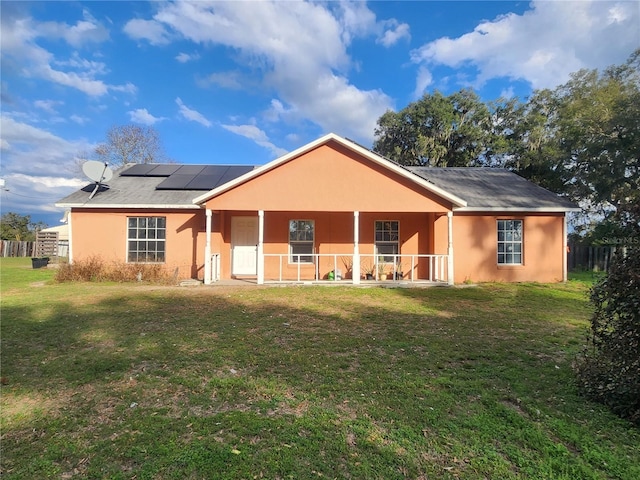 view of front of property featuring a front yard and solar panels