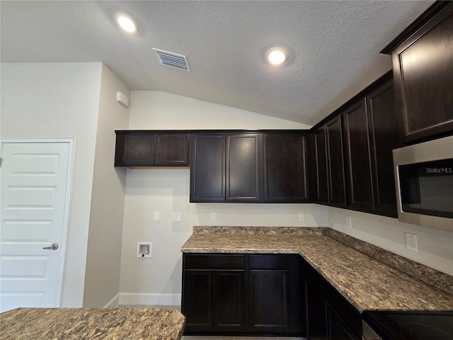336 W Twisted Oaks Dr, Beverly Hills, FL 34465 - kitchen with stainless steel microwave, lofted ceiling, a textured ceiling, dark stone countertops, and dark brown cabinets