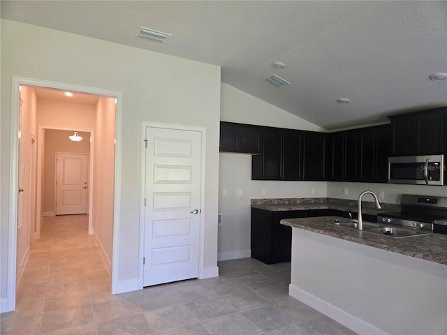 336 W Twisted Oaks Dr, Beverly Hills, FL 34465 - kitchen featuring appliances with stainless steel finishes, dark cabinets, lofted ceiling, dark stone counters, and light tile patterned floors