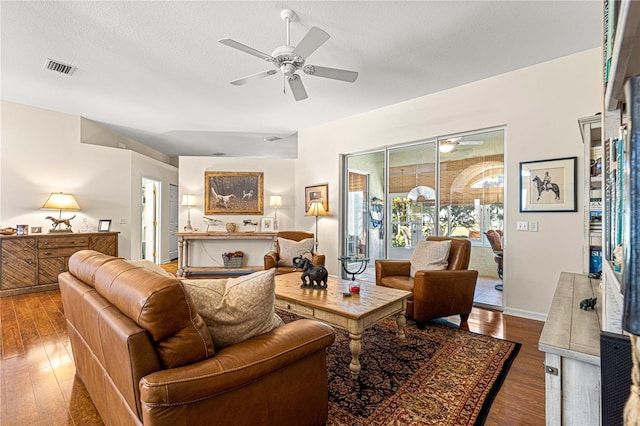 living room with hardwood / wood-style floors, a textured ceiling, and ceiling fan