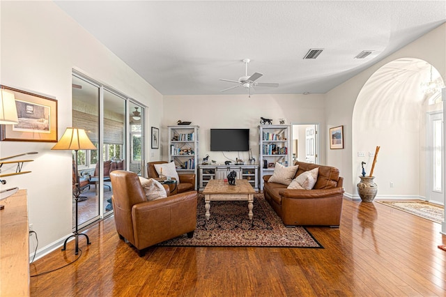 living room featuring hardwood / wood-style flooring, a textured ceiling, and ceiling fan