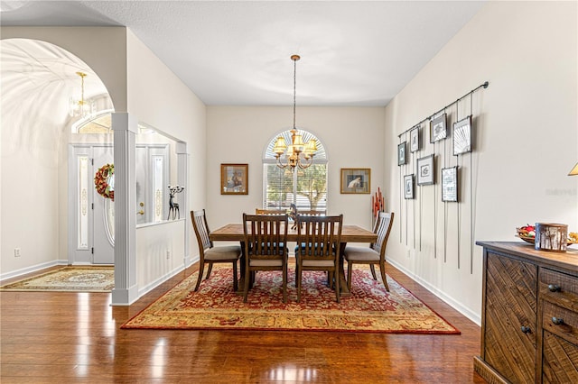 dining area featuring dark wood-type flooring and a chandelier