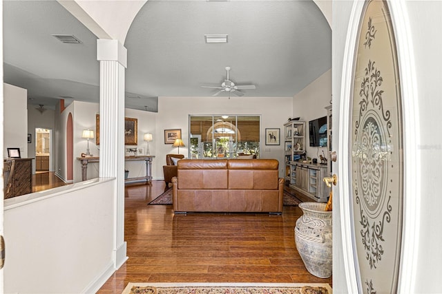 living room with hardwood / wood-style flooring, ceiling fan, decorative columns, and a textured ceiling