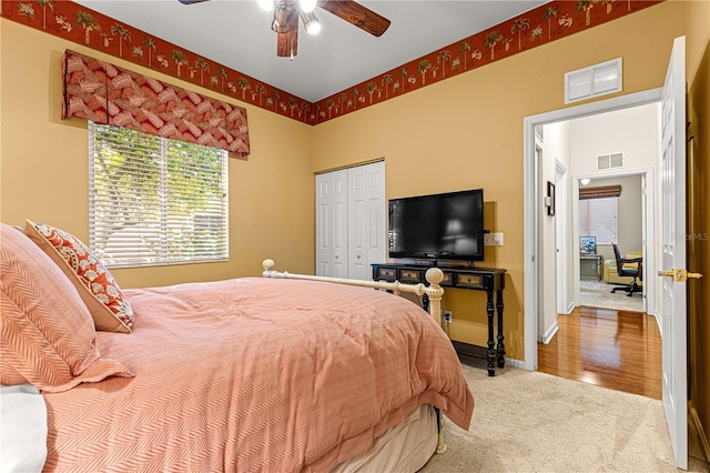 bedroom with ceiling fan, carpet flooring, and a closet