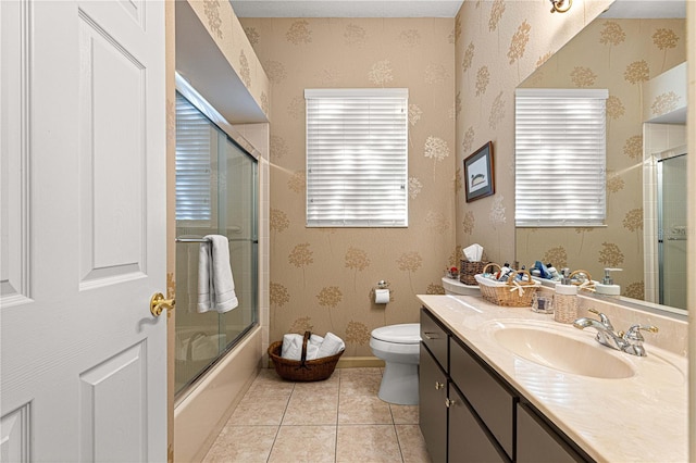 full bathroom featuring tile patterned flooring, vanity, combined bath / shower with glass door, and toilet