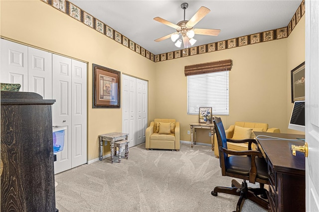 carpeted home office featuring ceiling fan