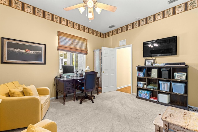 carpeted office space featuring ceiling fan