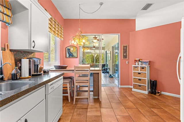 kitchen with white cabinetry, dishwasher, sink, hanging light fixtures, and a healthy amount of sunlight