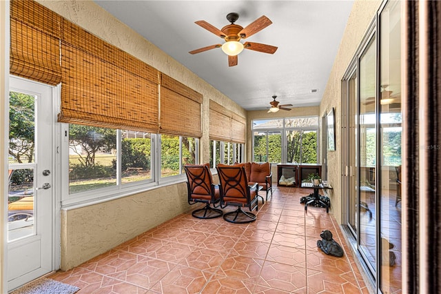 sunroom / solarium with a healthy amount of sunlight and ceiling fan