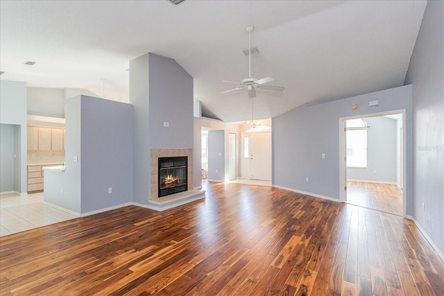 unfurnished living room with a fireplace, visible vents, light wood-style flooring, ceiling fan, and baseboards