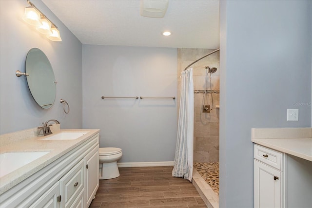 bathroom with wood finished floors, a stall shower, and a sink