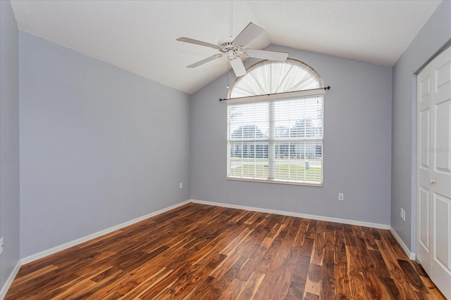 unfurnished bedroom with dark wood-style floors, baseboards, vaulted ceiling, and a ceiling fan