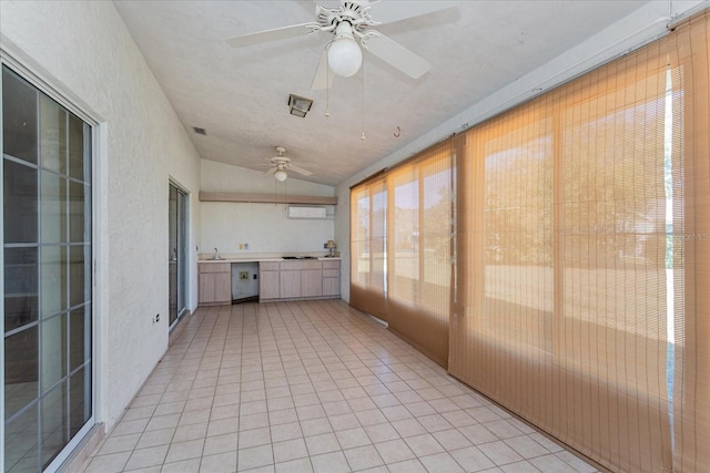 unfurnished sunroom with lofted ceiling, ceiling fan, visible vents, and a sink