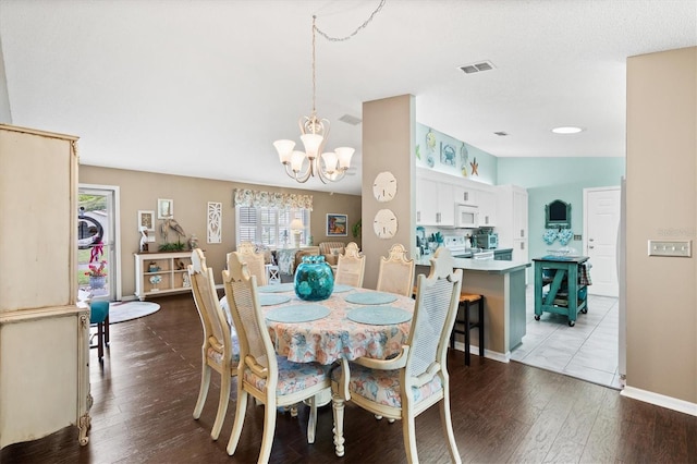 dining space featuring hardwood / wood-style flooring and a notable chandelier