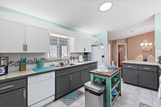 kitchen with gray cabinetry, white appliances, white cabinets, decorative light fixtures, and sink