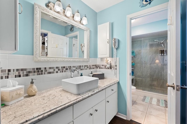 bathroom featuring toilet, a shower with door, backsplash, and vanity