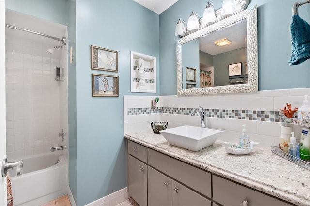 bathroom with vanity, tasteful backsplash, and tiled shower / bath combo