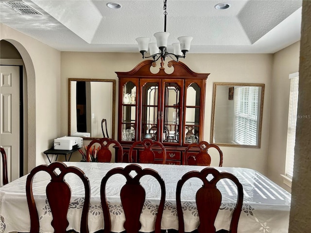 dining space featuring an inviting chandelier and a textured ceiling