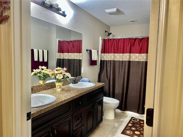 bathroom featuring vanity, tile patterned floors, toilet, and a textured ceiling