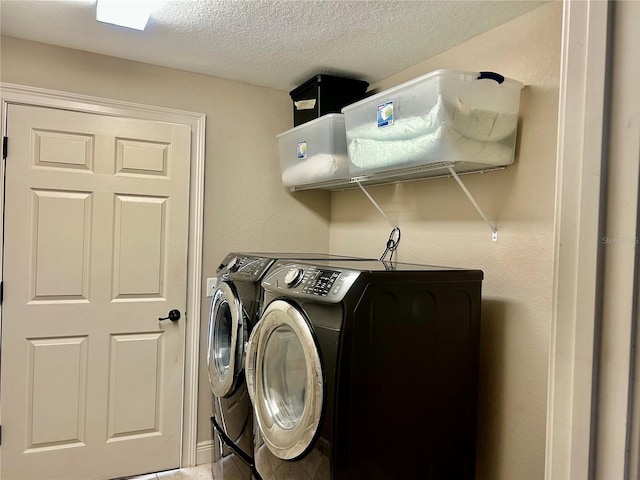 washroom with washer and dryer and a textured ceiling