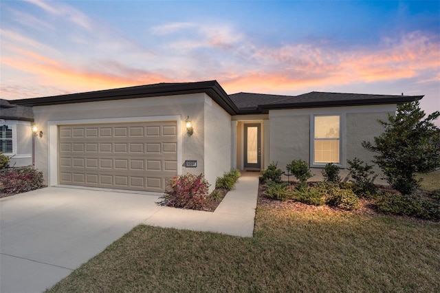 view of front of property with a garage and a lawn