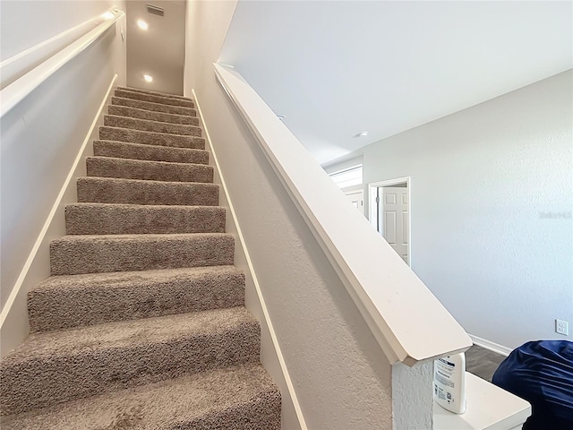 stairway featuring visible vents and baseboards